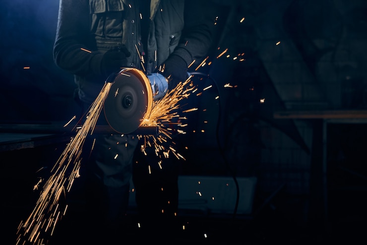 young-man-cutting-with-rotating-disc-metal-with-sparks_7502-7396